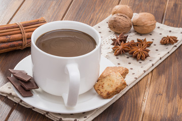 Mug filled with homemade hot chocolate, cookie with walnut