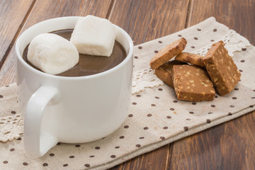 Mug filled with homemade hot chocolate and marshmallow, cookie