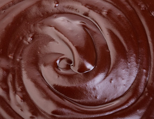 Melted dark chocolate flow, candy or chocolate preparation close-up as a background.