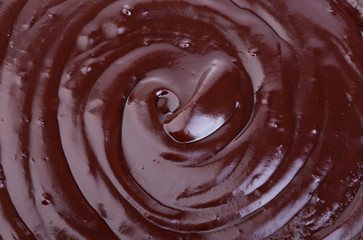Melted dark chocolate flow, candy or chocolate preparation close-up as a background.