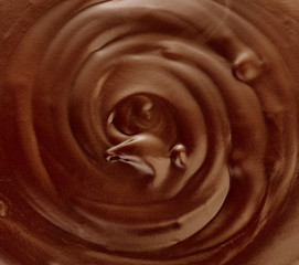 Melted dark chocolate flow, candy or chocolate preparation close-up as a background.