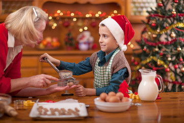 happy grandmother and little boy in kitchen preparing Xmas cooki