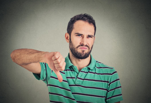 angry, unhappy, young man showing thumbs down sign