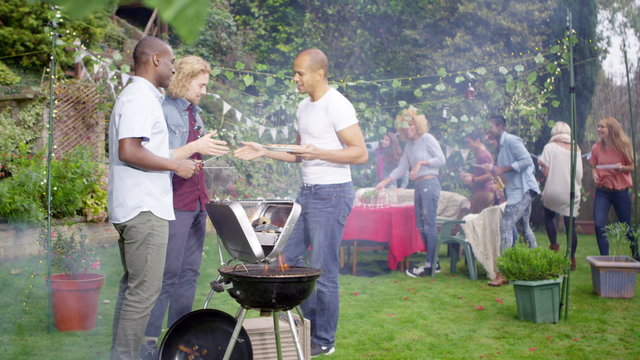  Happy mixed ethnicity group of friends chatting & having fun at bbq party