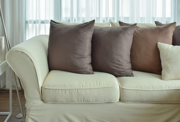Dark brown pillows setting on beige color sofa