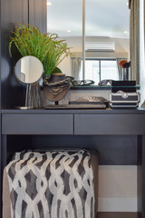 black wooden dressing table with brown chair and accessories at