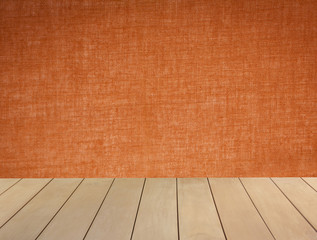 Wooden floor with blank orange fabric wall background