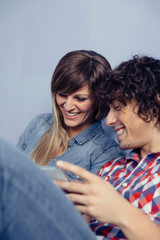 Couple in love looking smartphones and laughing