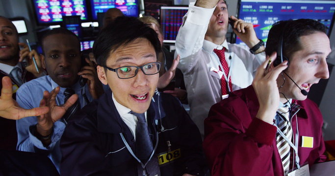  Diverse group of stockmarket traders frantically buying and selling on the trading floor. Shot on RED Epic.