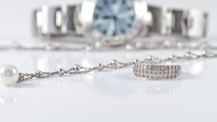 Silver ring and chain on the background of watches