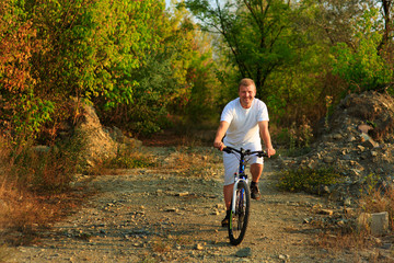 Young man cycling  in the forest
