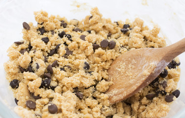 Stirring chocolate chips into cookie dough