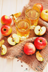 
apple cider with fresh apples , cinnamon , spices and chips on a wooden background