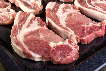 chunks of fresh pork meat on a baking sheet
