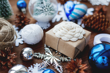 Christmas and New year background with blue decorations and gift with crochet flower.