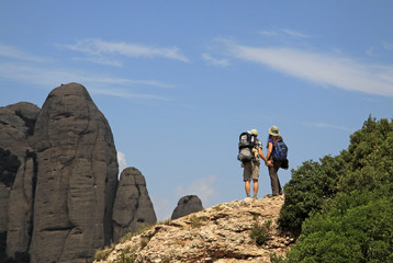 MONTSERRAT, SPAIN - AUGUST 28, 2012: Tourists on hiking path in the mountains near Benedictine abbey Santa Maria de Montserrat in Monistrol de Montserrat, Spain