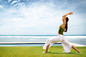 woman practicing yoga at the seaside