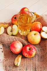 
apple cider with fresh apples , cinnamon , spices and chips on a wooden background