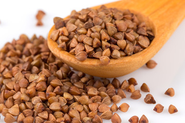 Uncooked buckwheat on wooden spoon