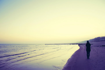 Lonely woman walking on the beach.