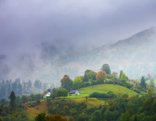 Foggy autumn day in mountains . Green hills . Fairy landscape . Birth of clouds .