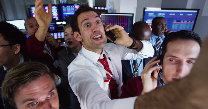 Diverse group of stock market traders frantically buying and selling on the trading floor