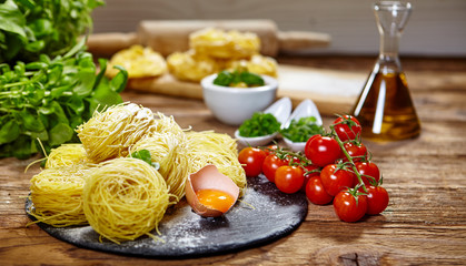 Pasta ingredients on table, with little olive oil bottle and rol