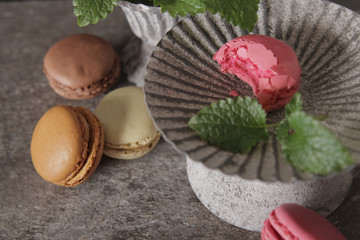 macarons in gray vintage vase with mint. on a gray stone backgro