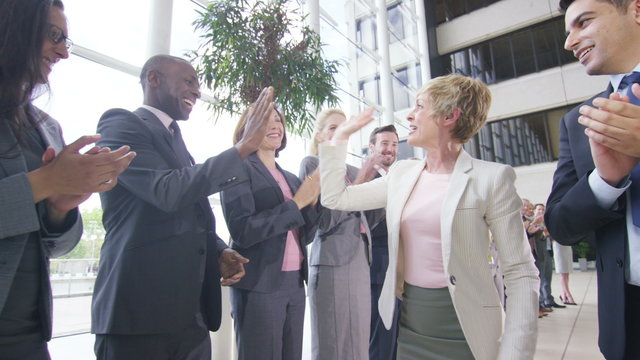  Confident diverse business team applauding their success and shaking hands