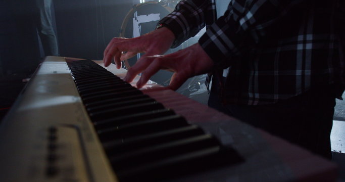  Focus on keyboard player in a rock band performing at live music event