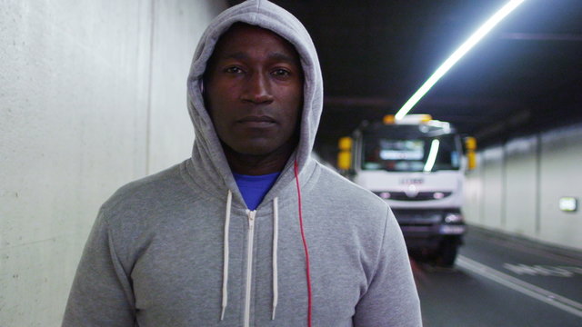  Portrait of athletic black male in a hooded sweatshirt, in urban environment. Could be an athlete in training or a suspicious character.