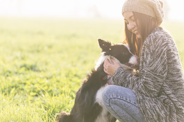 Young woman playing with her border collie dog
