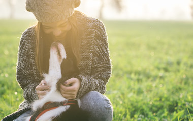 Young woman playing with her border collie dog