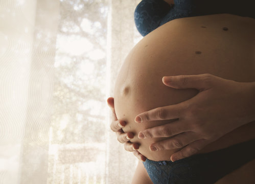 Donna incinta che accarezza il suo pancione durante la gravidanza
