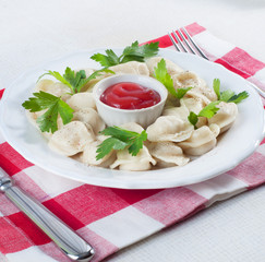 Freshly cooked ravioli with ketchup and parsley leaves