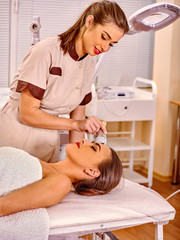 Obraz na płótnie Canvas Young woman receiving electric facial massage.