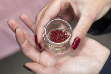 Woman holding jar of saffron.