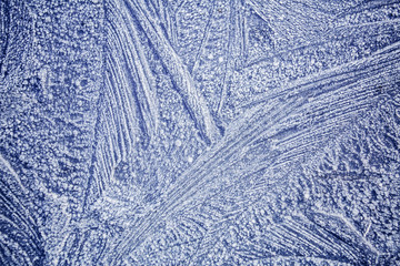 Ice patterns on winter glass . Frozen flowers. Frozen fern. Blue color. Macro lens.