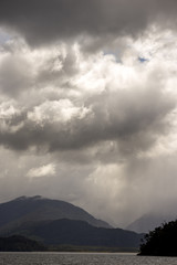 thunder storm cloud on top of a mountain and a lake