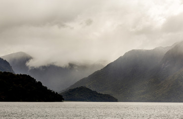 rain cloud on top of mountains and a lake