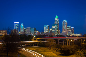 Fototapeta na wymiar The top of the tallest tower in Charlotte, North Carolina lit up green in support of our military taken during the evening rush hour commute