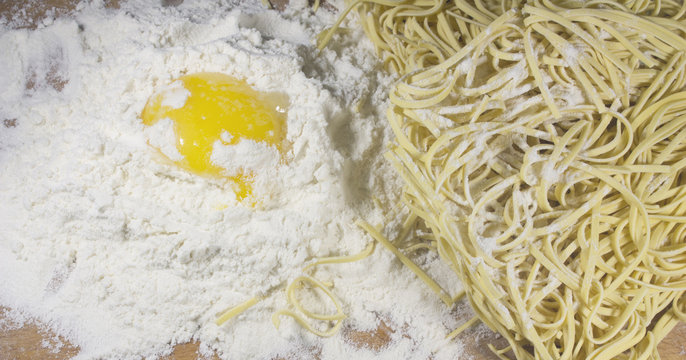 Asian Noodle and Egg with Flour on Wooden Table Closeup