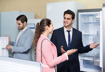 couple choosing new refrigerator in hypermarket