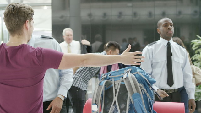  Airport security guards on duty, searching passengers before a flight