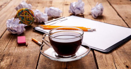 Crumpled paper balls with pencil and clipboard on wooden background, cup of coffee, a wrong idea, business concept