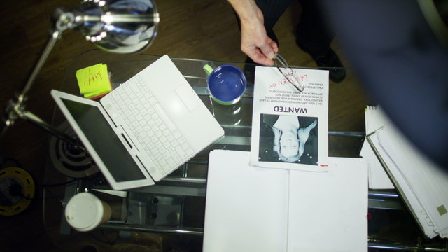  Overhead view of Police detective working alone at his desk