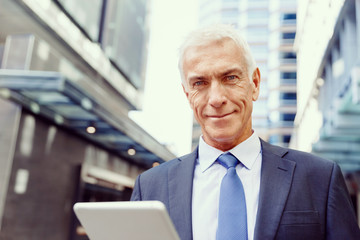 Senior businessman holding touchpad 