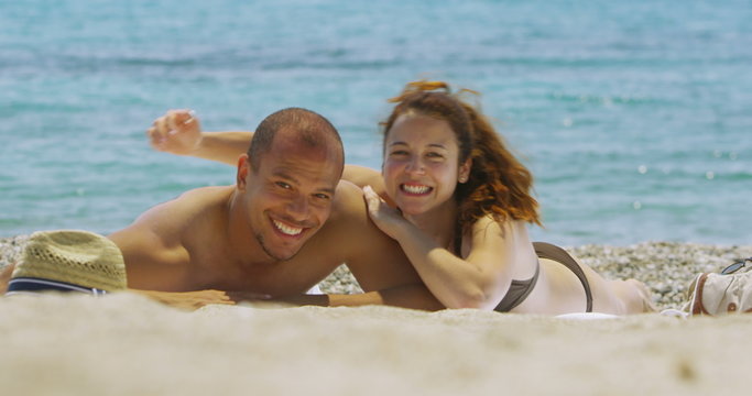  Portrait of happy smiling couple sunbathing at the beach. 
