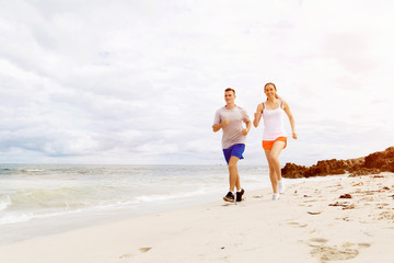 Runners. Young couple running on beach
