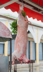 Beheaded piglet hangs for sale at the restaurant on the way to R